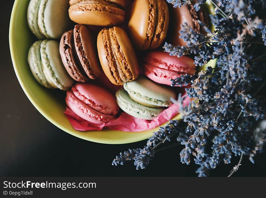 A cup of French macarons with lavender flowers.