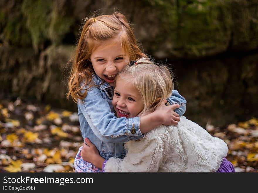 2 Girls Hugging Each Other Outdoor during Daytime