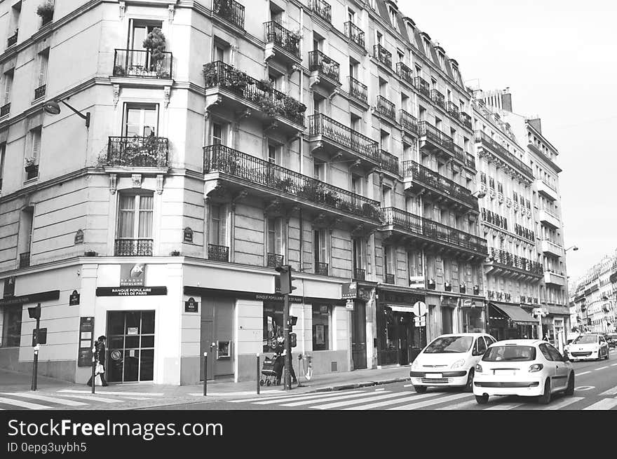 Exterior of city buildings along streets with traffic in black and white. Exterior of city buildings along streets with traffic in black and white.