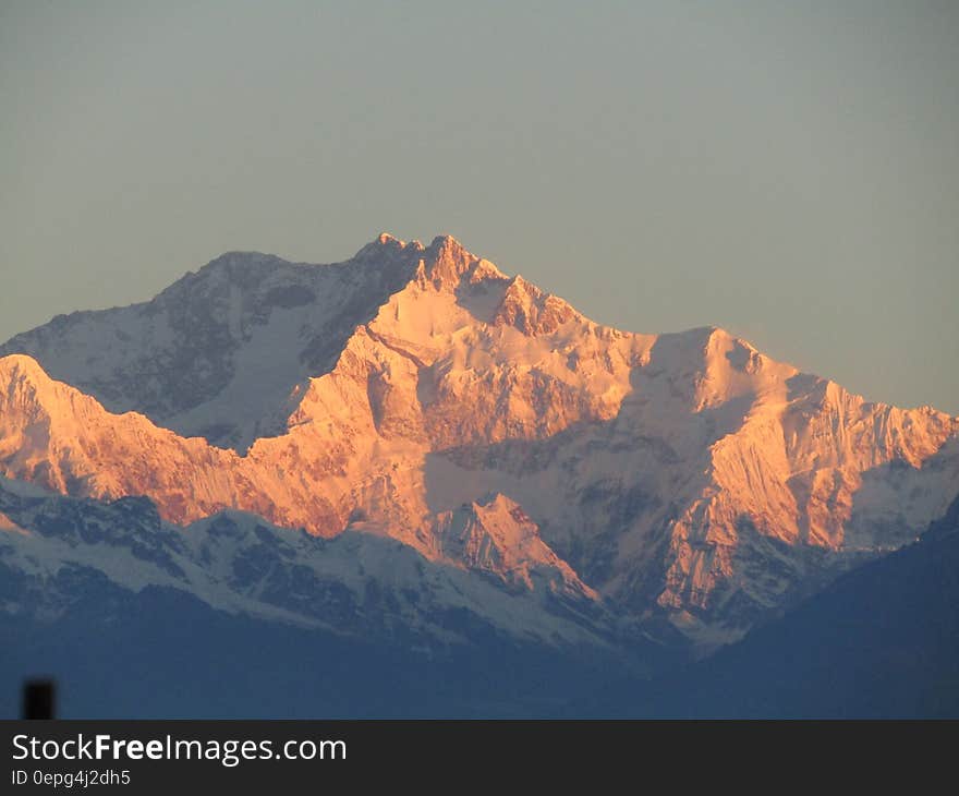 Scenic View of Snowcapped Mountains Against Sky at Sunset