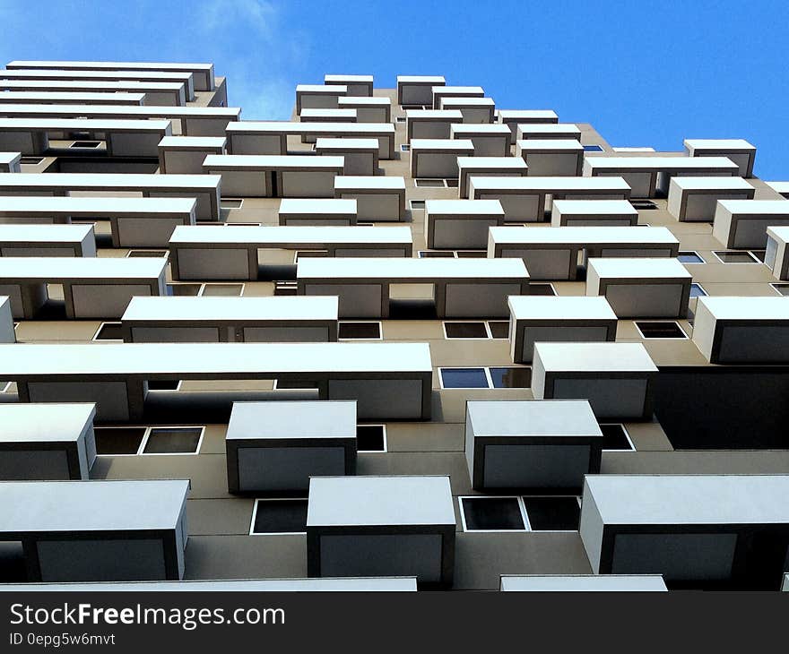 High rise apartment block with almost identical windows and balconies, clear blue sky background. High rise apartment block with almost identical windows and balconies, clear blue sky background.