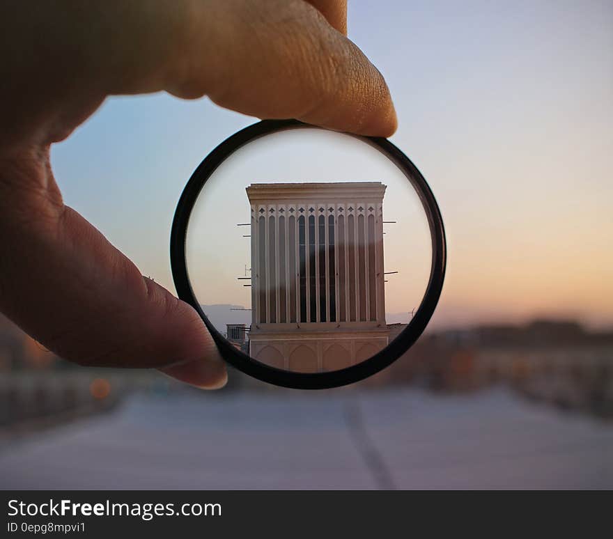 Hand holding filter over exterior of architecture to focus. Hand holding filter over exterior of architecture to focus.