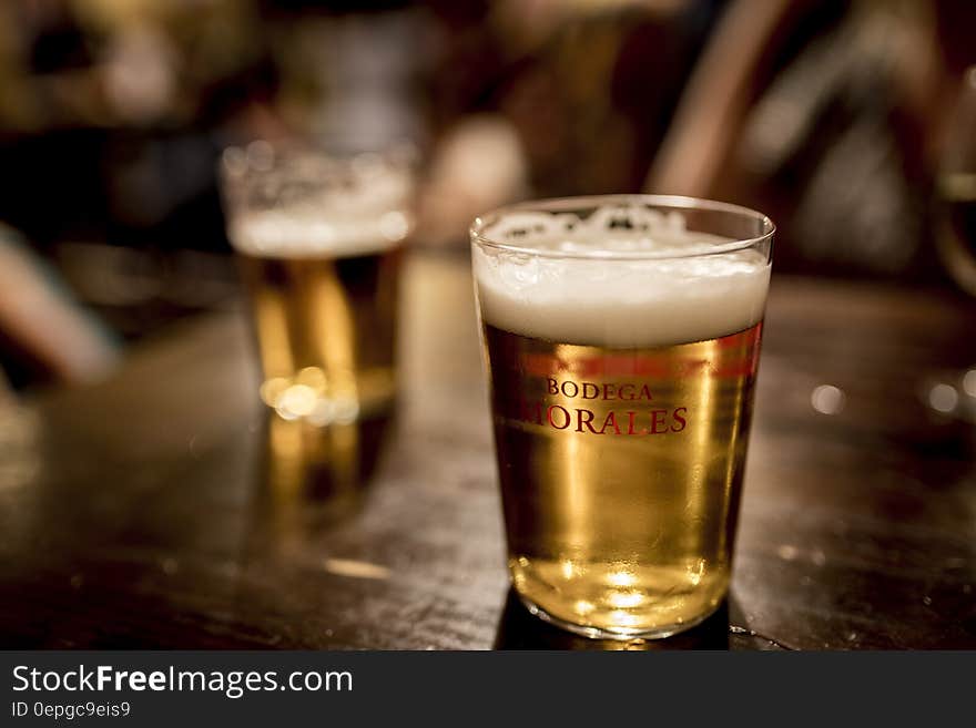 Close up of glasses of beer on indoor wooden table. Close up of glasses of beer on indoor wooden table.