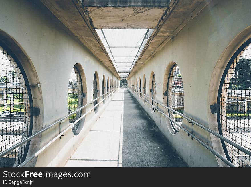 Urban covered bridge and walkway over road on sunny day.