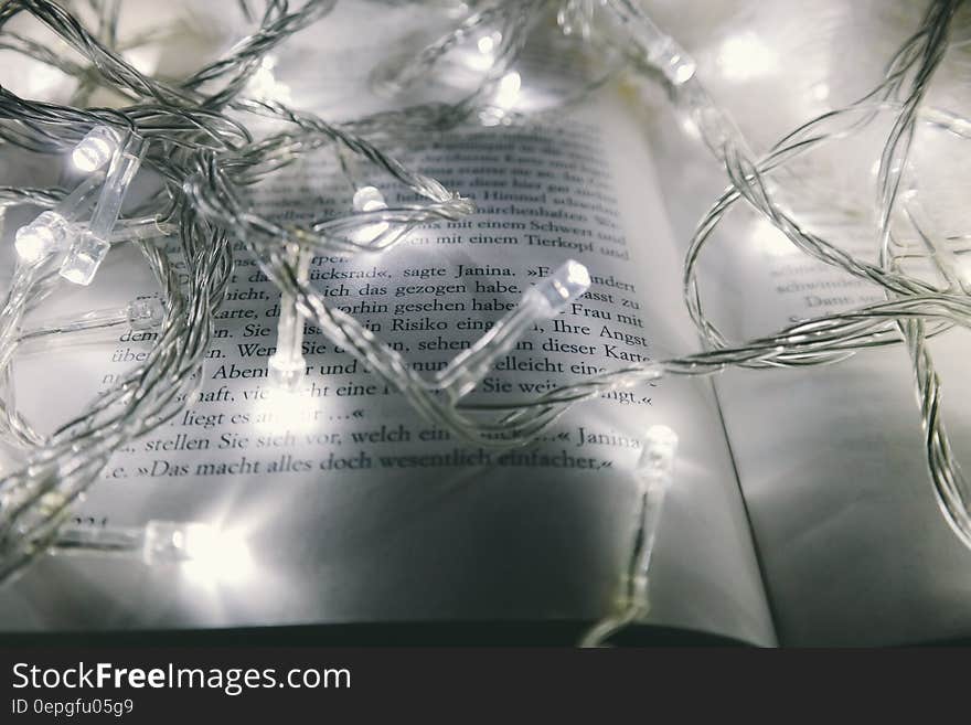 Close up of lit Christmas lights on open book. Close up of lit Christmas lights on open book.