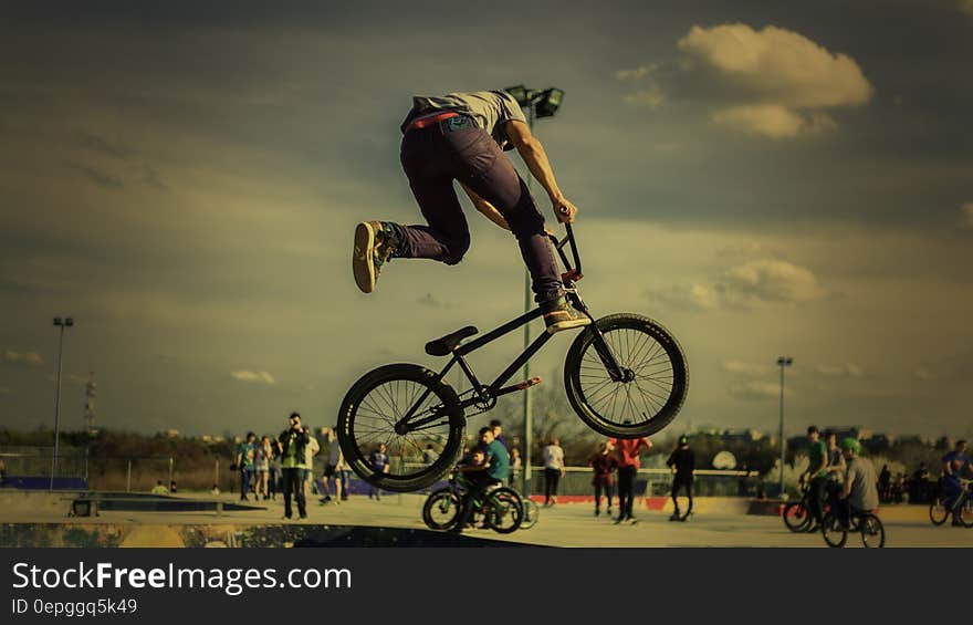 Man performing tricks on bicycle at skate park on sunny day. Man performing tricks on bicycle at skate park on sunny day.