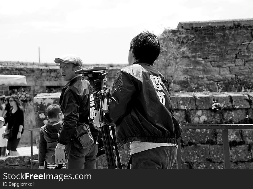 Boy with camera and tripod outside at event. Boy with camera and tripod outside at event.