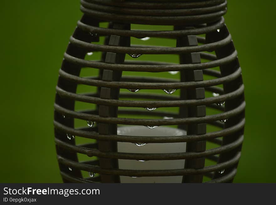 Close up of water drops on metal container against green background.