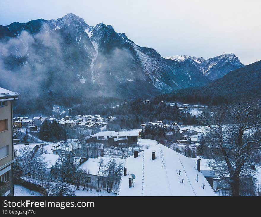 Snow Covered House Near Snow Covered Mountain Under Clear Sky