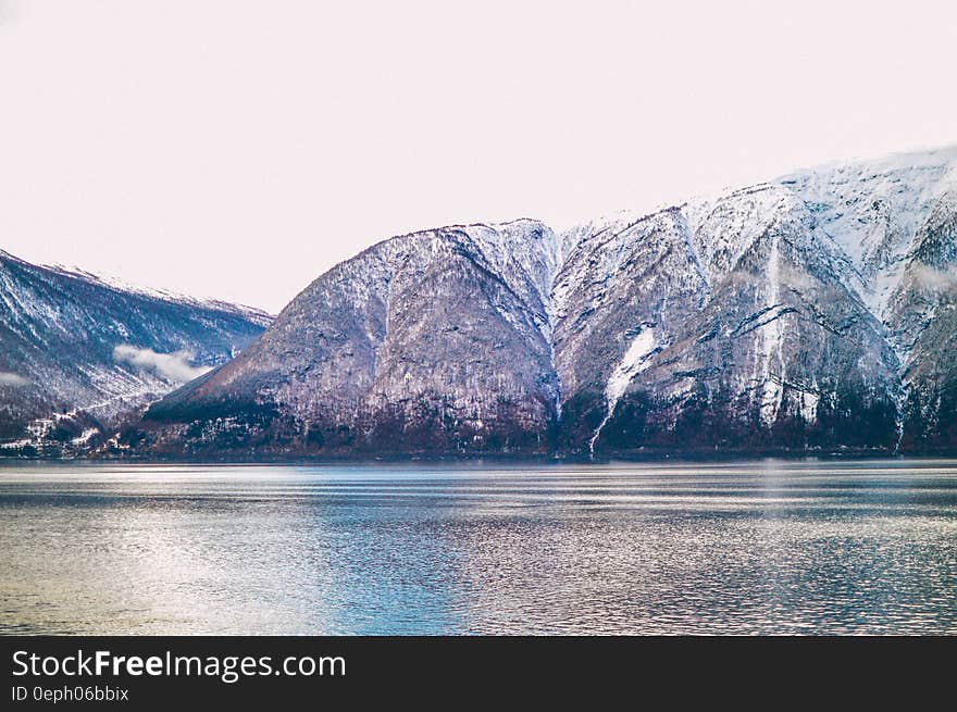 A lake with snowy mountain range behind it. A lake with snowy mountain range behind it.