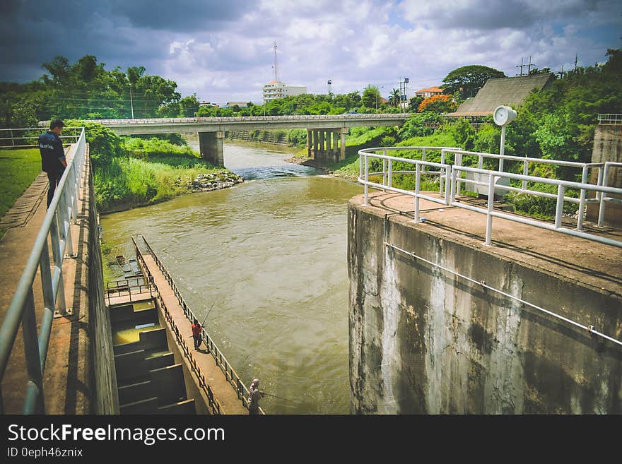 Man Standing by White Railing Near River