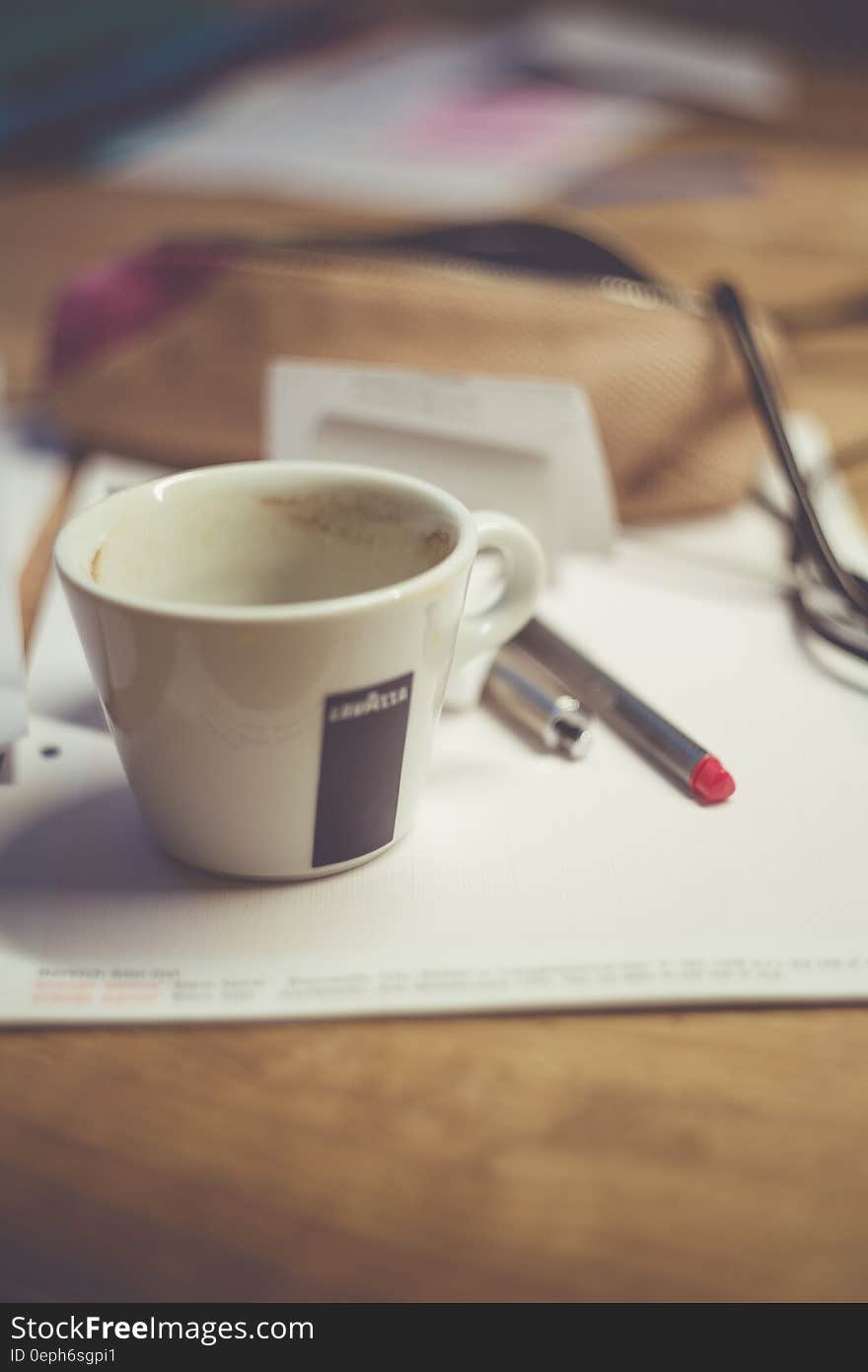 White Ceramic Mug on White Table Near Grey Pen