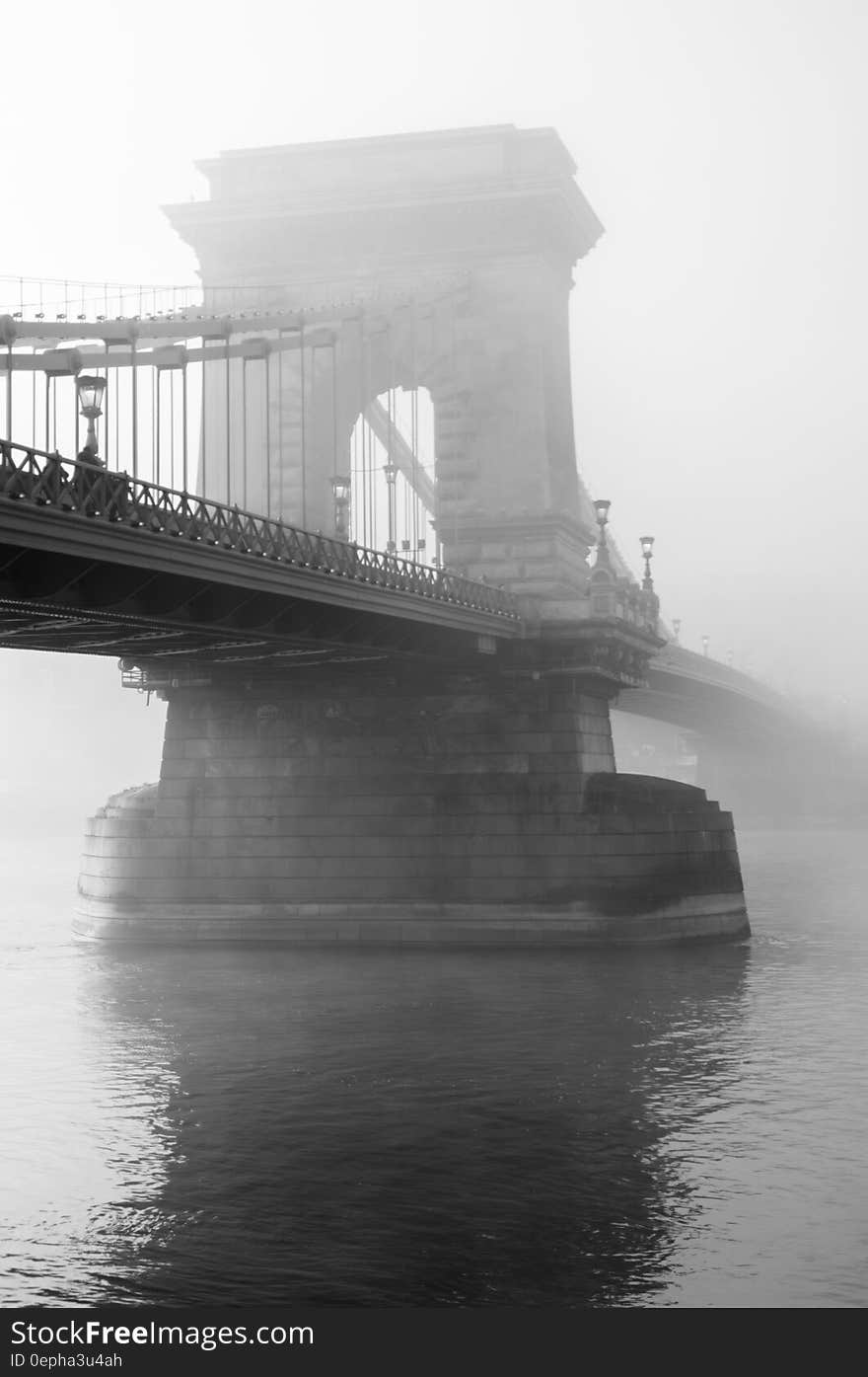 Fog over stone stanchion of suspension bridge in black and white. Fog over stone stanchion of suspension bridge in black and white.