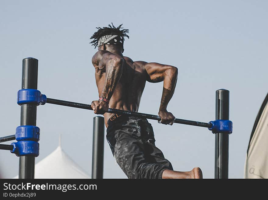 A man doing his workout on a high bar. A man doing his workout on a high bar.