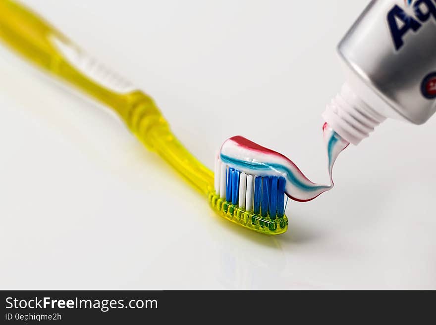 Toothpaste Being Put on Yellow Toothbrush