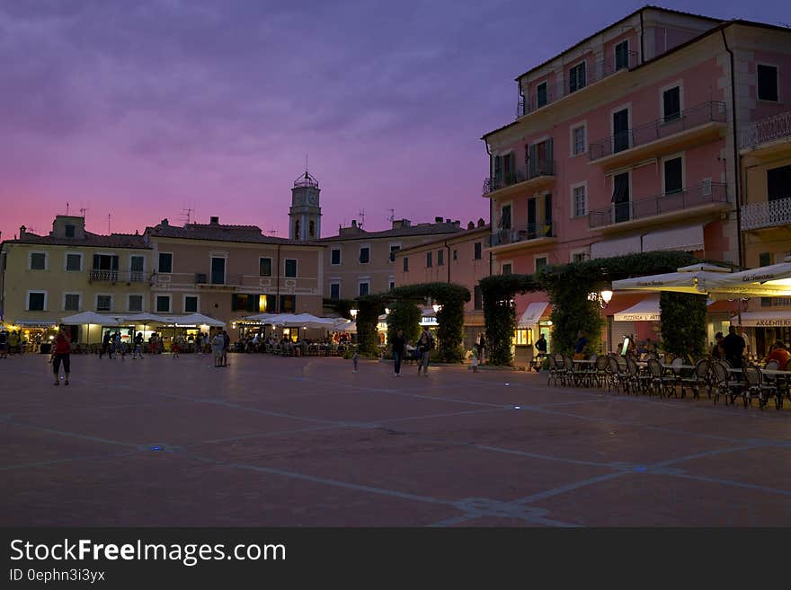 Outdoor restaurants in piazza in Italy at sunset.