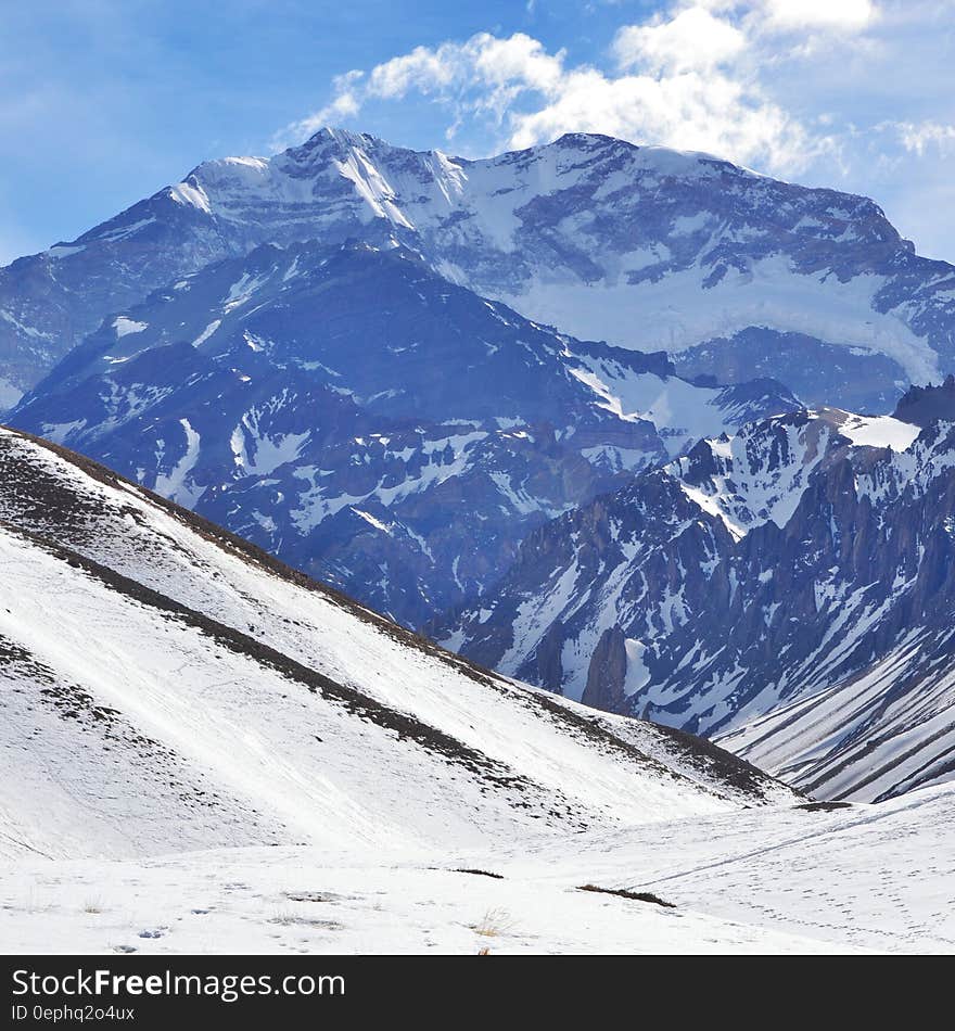 Snowy alpine hillside in mountains against blue skies on sunny day. Snowy alpine hillside in mountains against blue skies on sunny day.