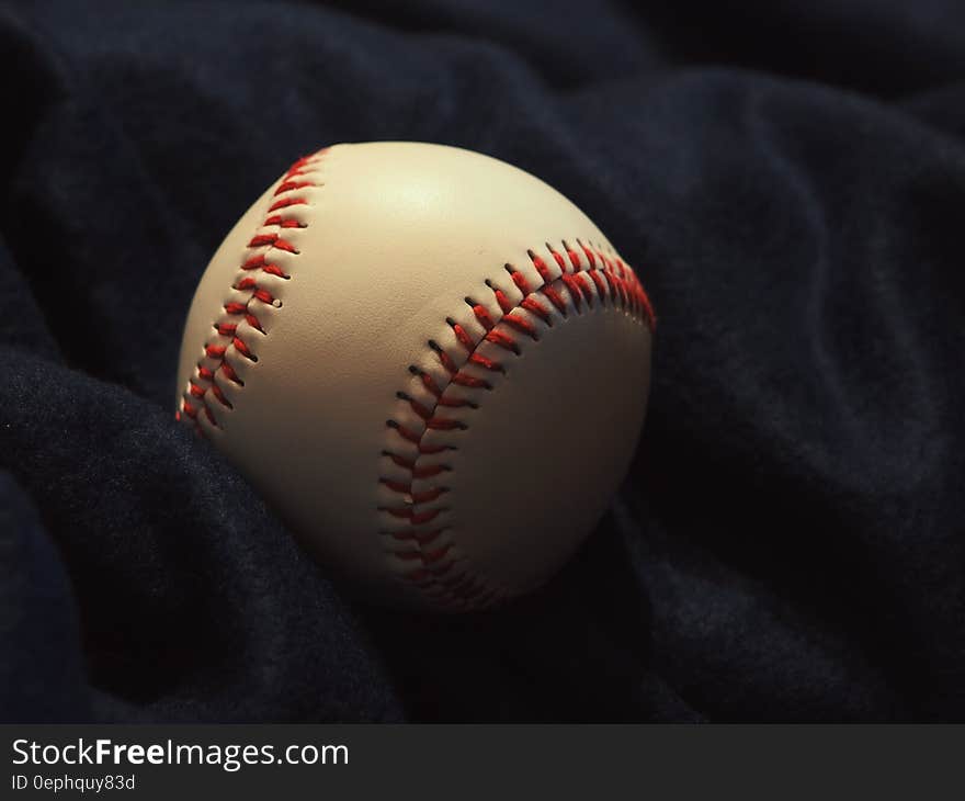 Close up of clean new leather baseball on black. Close up of clean new leather baseball on black.