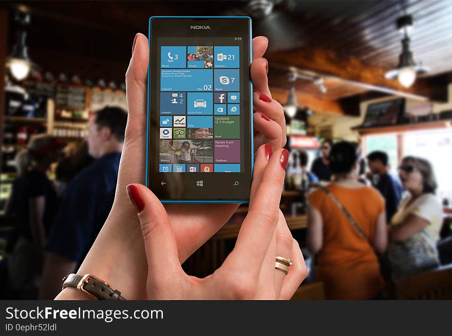 Woman Wearing Gold Ring Holding Blue Nokia Windows Smartphone