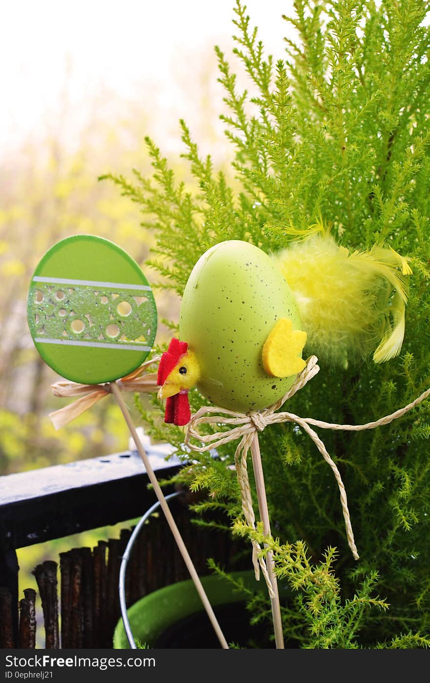 Easter decorations on sticks in potted plant outside on sunny day. Easter decorations on sticks in potted plant outside on sunny day.