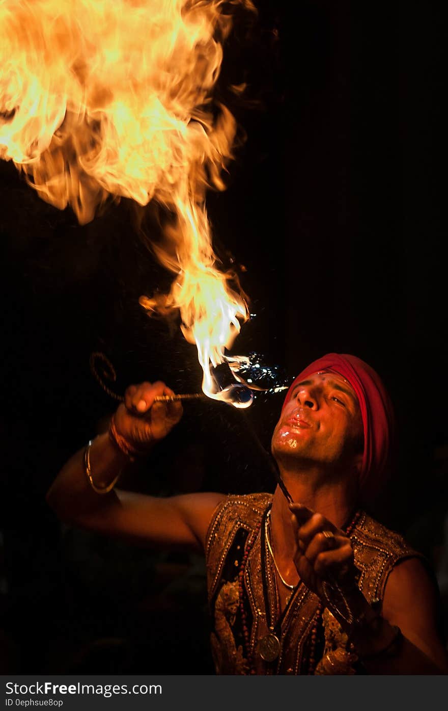 Man performing fire eating tricks against dark skies. Man performing fire eating tricks against dark skies.