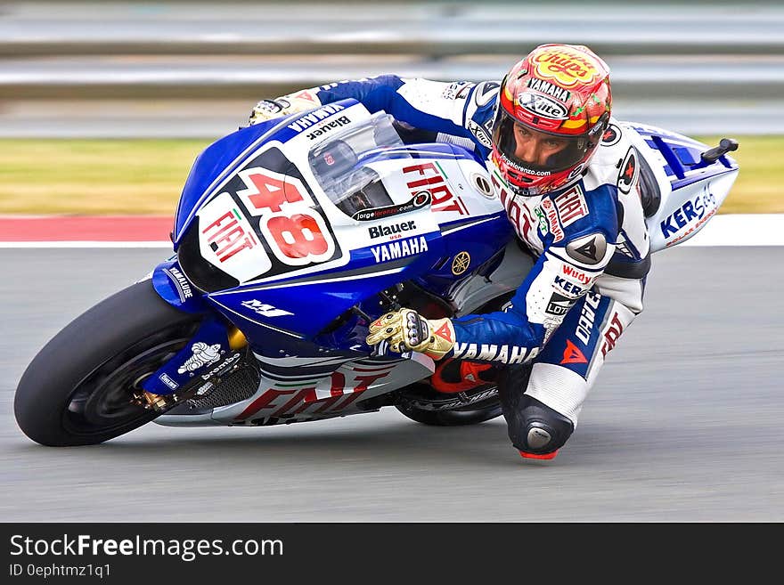 Competitor number 48 in motorbike race with bike covered by name of sponsoring companies using bike to advertise. Competitor number 48 in motorbike race with bike covered by name of sponsoring companies using bike to advertise.