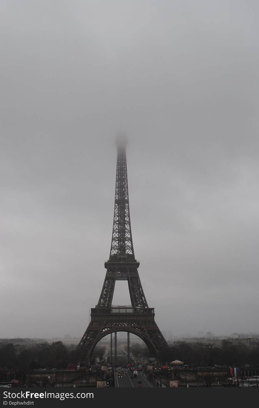 Monochrome view of Eiffel tower in Paris on foggy day, France.