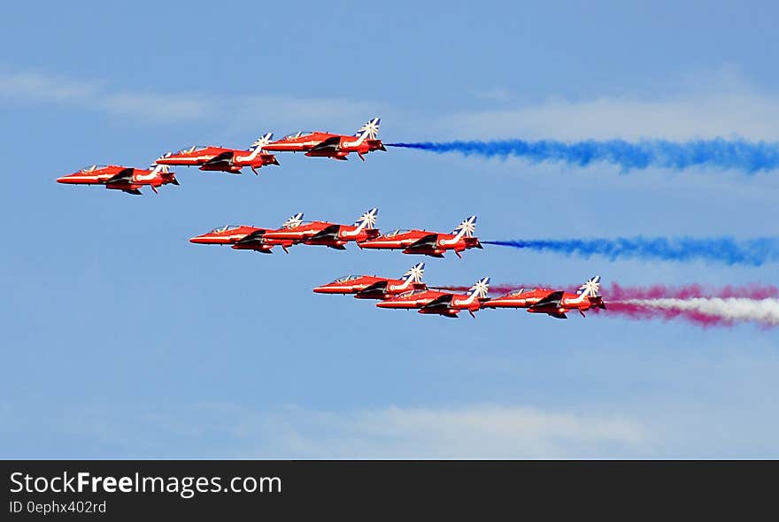 Red Jet Fighter Planes With Assorted Colors of Smoke on Horizon