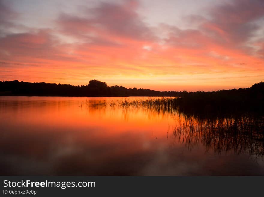 Sun setting over reeds along banks of lake. Sun setting over reeds along banks of lake.