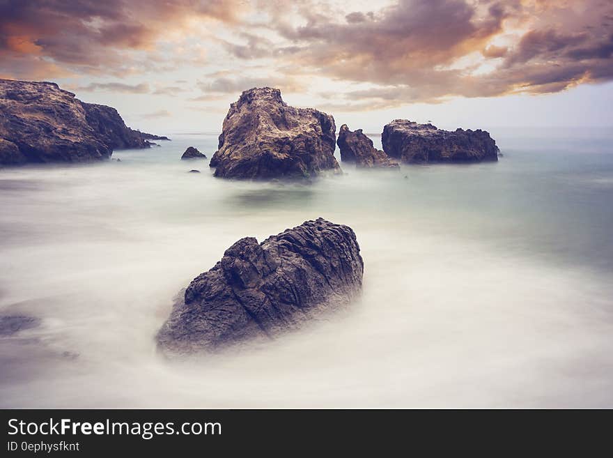 Scenic landscape of large rocks and mist by the ocean. Scenic landscape of large rocks and mist by the ocean.