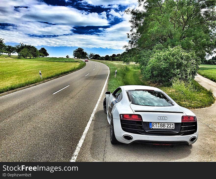 White Audi Coupe on Gray Concrete Road during Textile