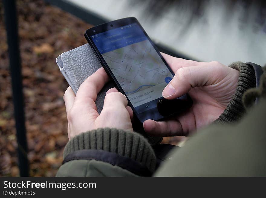 Hands of person looking at directions using map on smartphone. Hands of person looking at directions using map on smartphone.