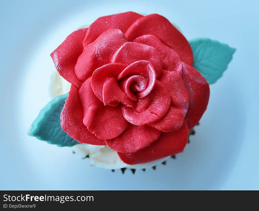 A cupcake decorated with a red fondant rose. A cupcake decorated with a red fondant rose.