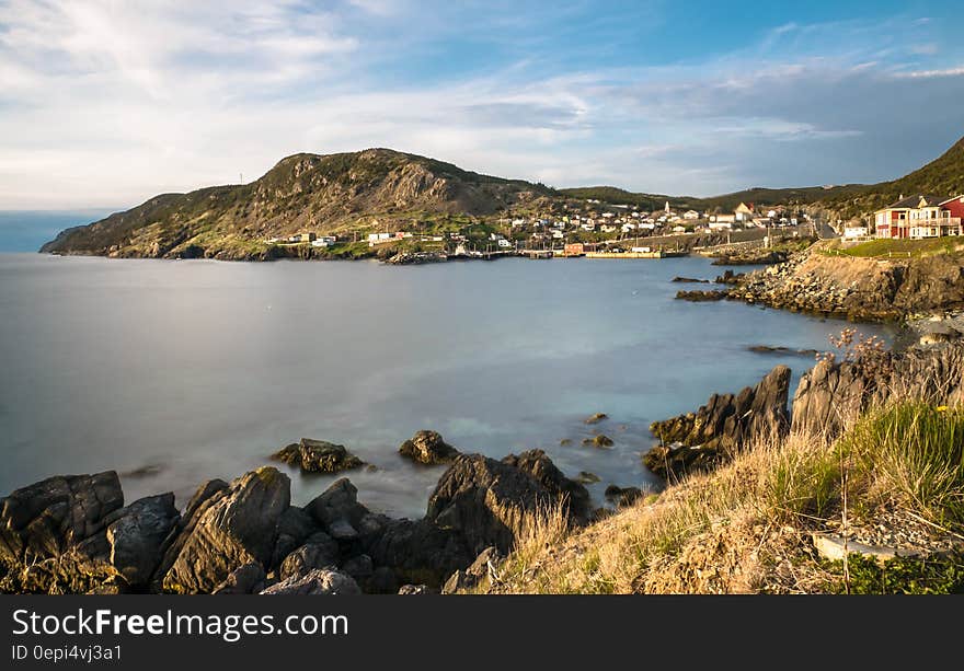 A rocky seacoast of a bay and a small town in the background. A rocky seacoast of a bay and a small town in the background.