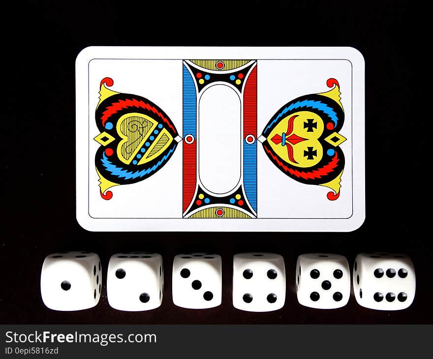 A pack of cards and a dice set on a black background. A pack of cards and a dice set on a black background.