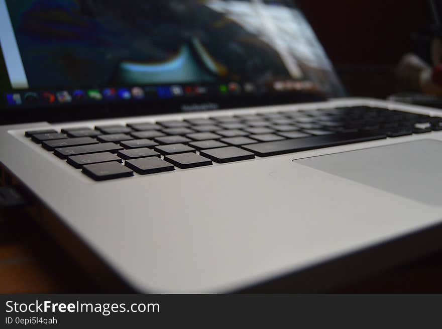 Closeup of light gray laptop computer with selective focus on keys, dark background. Closeup of light gray laptop computer with selective focus on keys, dark background.