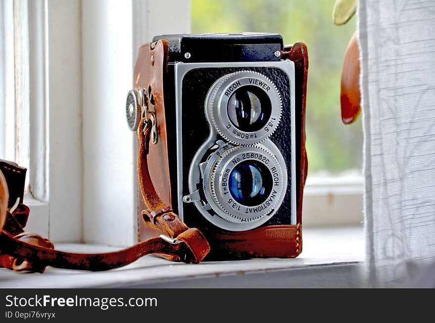 Vintage twin lens reflex camera on a window sill.