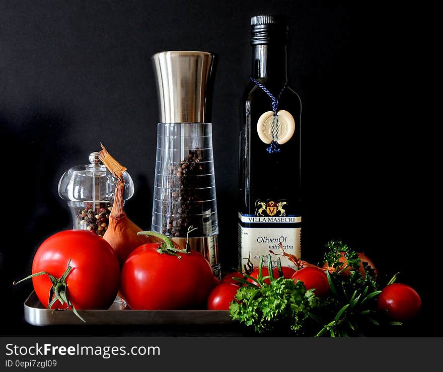 Tomatoes Beside Shakers and Olive Oil Bottle