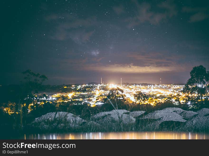 A city seen from the distance at night with starry sky above. A city seen from the distance at night with starry sky above.