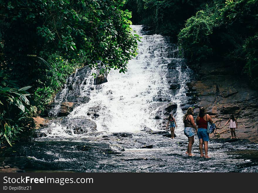 Travelers watching a tropical waterfall from downstream. Travelers watching a tropical waterfall from downstream.