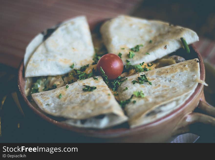 Four Mexican quesadillas on a clay pot.