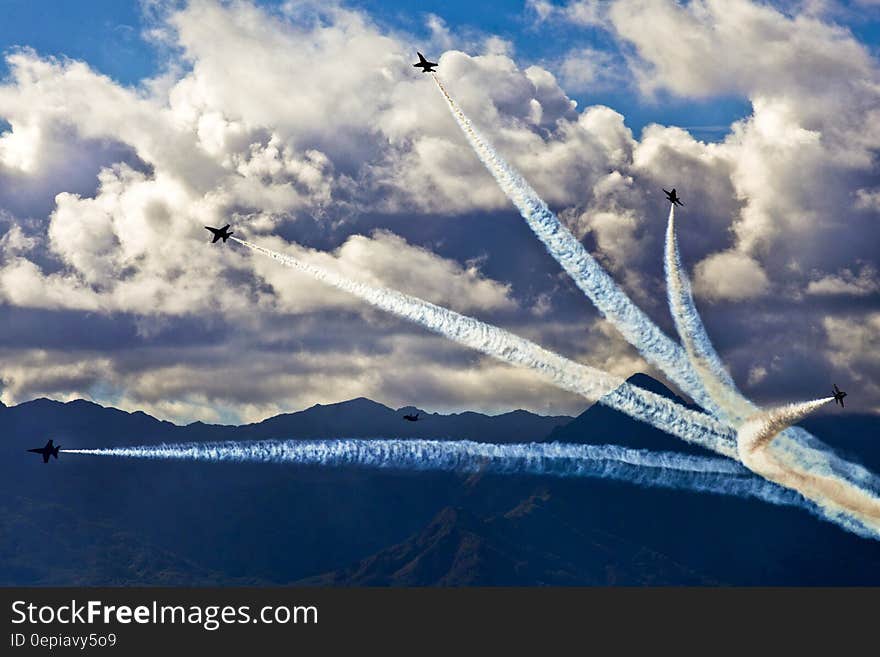 A group of jet fighter planes doing an aerobatics display in an air show. A group of jet fighter planes doing an aerobatics display in an air show.