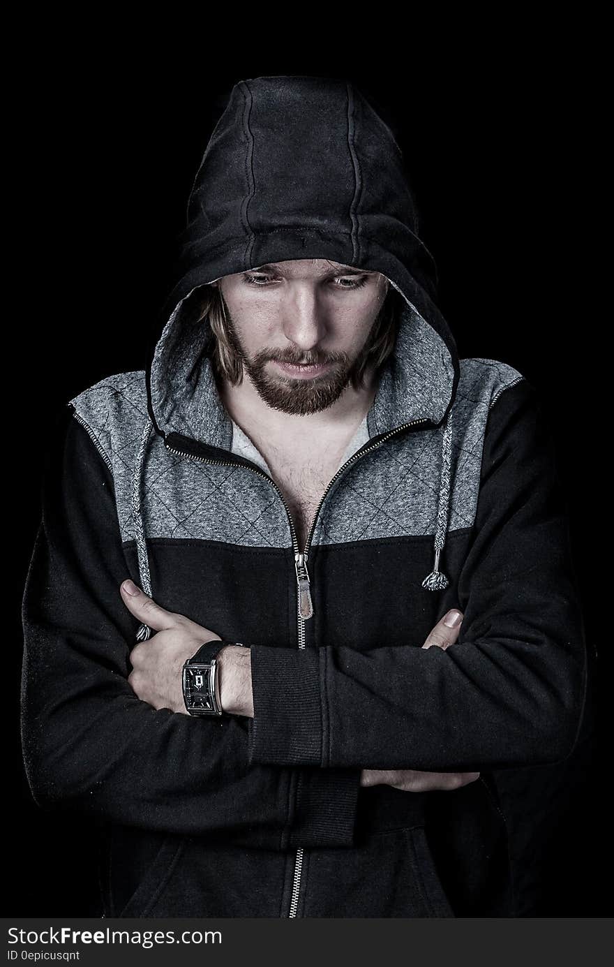 Studio portrait of man in hoodie jacket with serious expression.