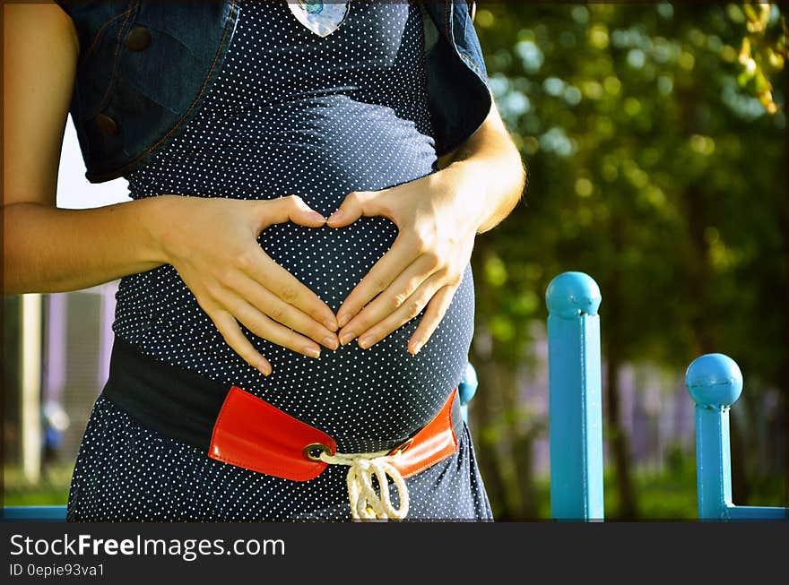 Pregnant Woman Holding Her Tummy during Daytime