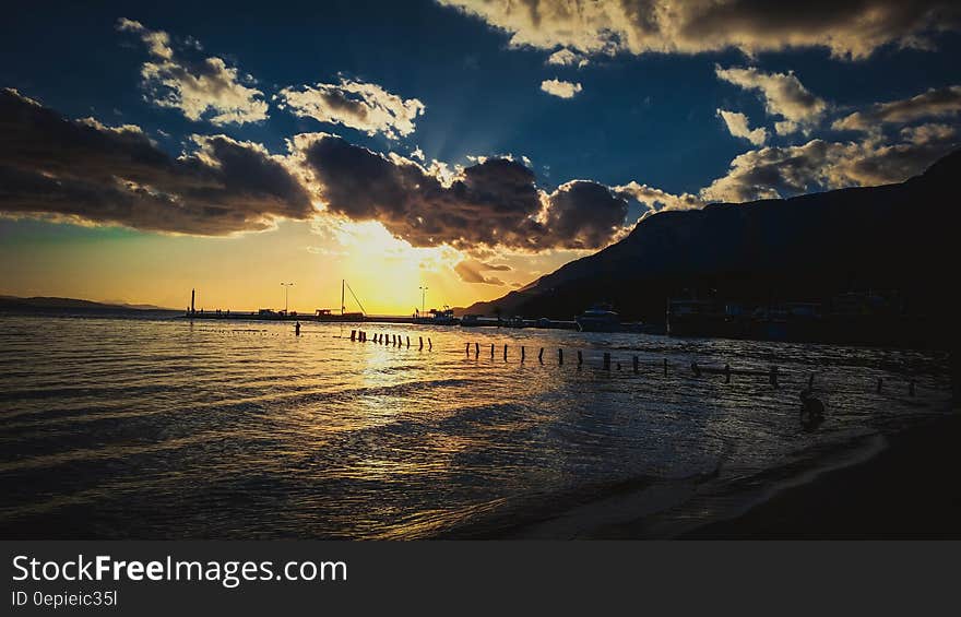 Sunset over wooden piles in coastal marina. Sunset over wooden piles in coastal marina.