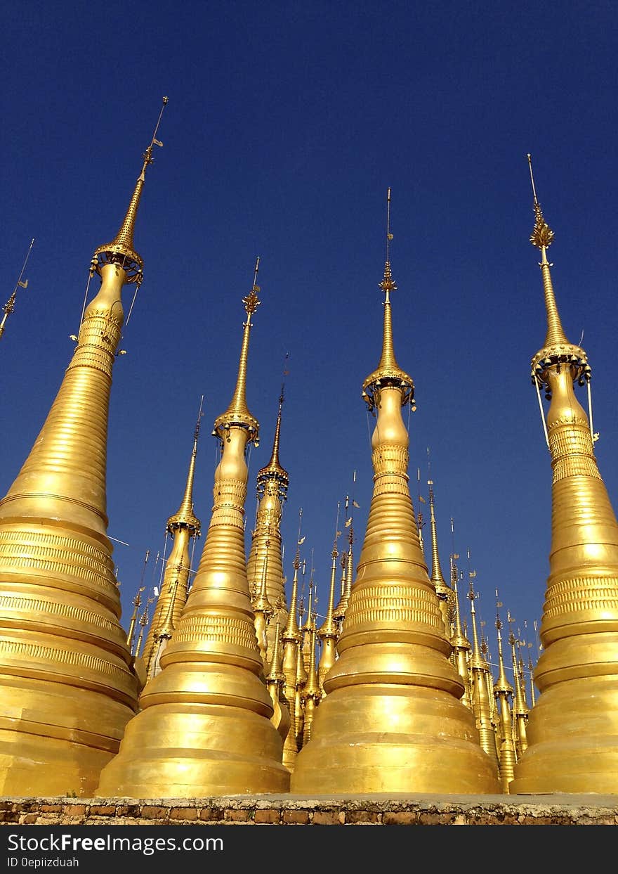 Gold Buddhist pagoda spires against blue skies in Myanmar. Gold Buddhist pagoda spires against blue skies in Myanmar.