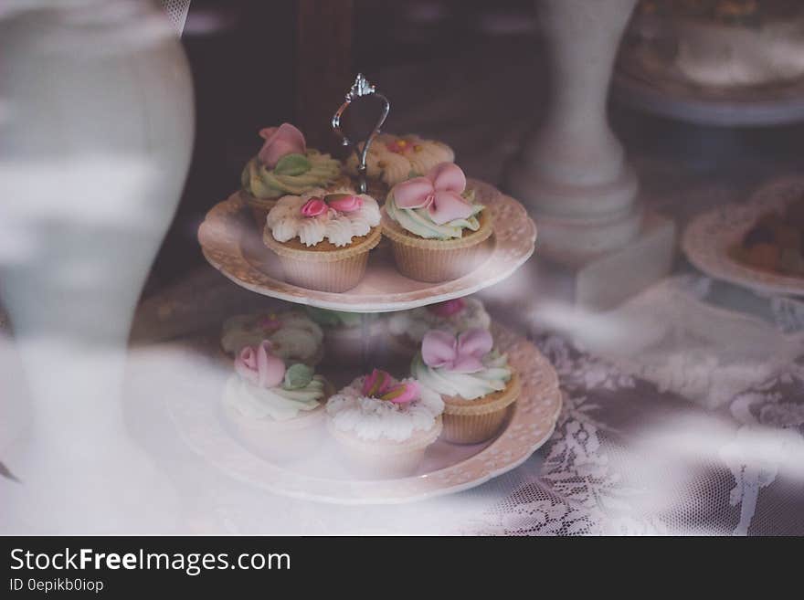 Beige White Cupcake on 2 Layer Stand Near White Baluster