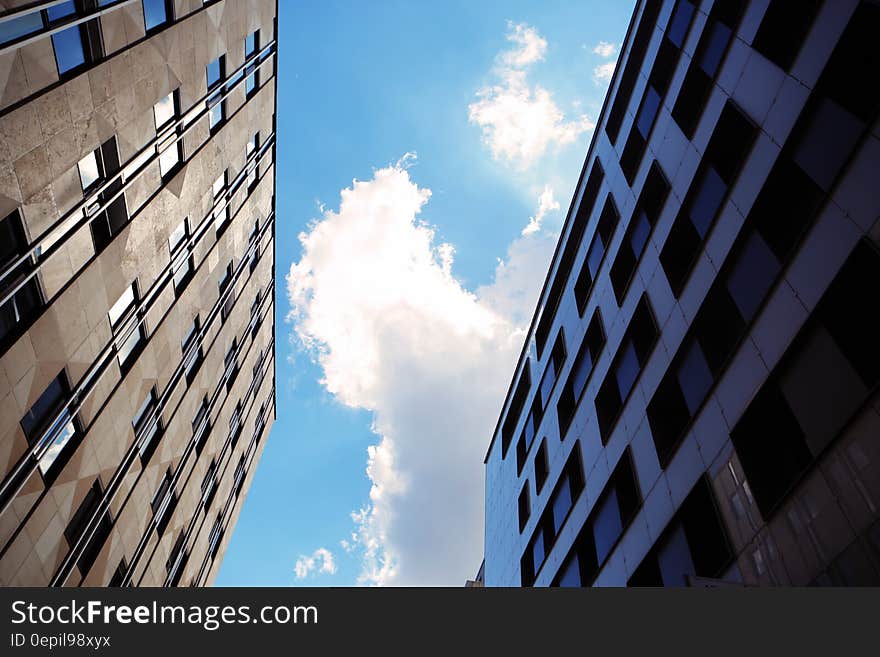 Facade of high rise buildings against blue skies on sunny day.