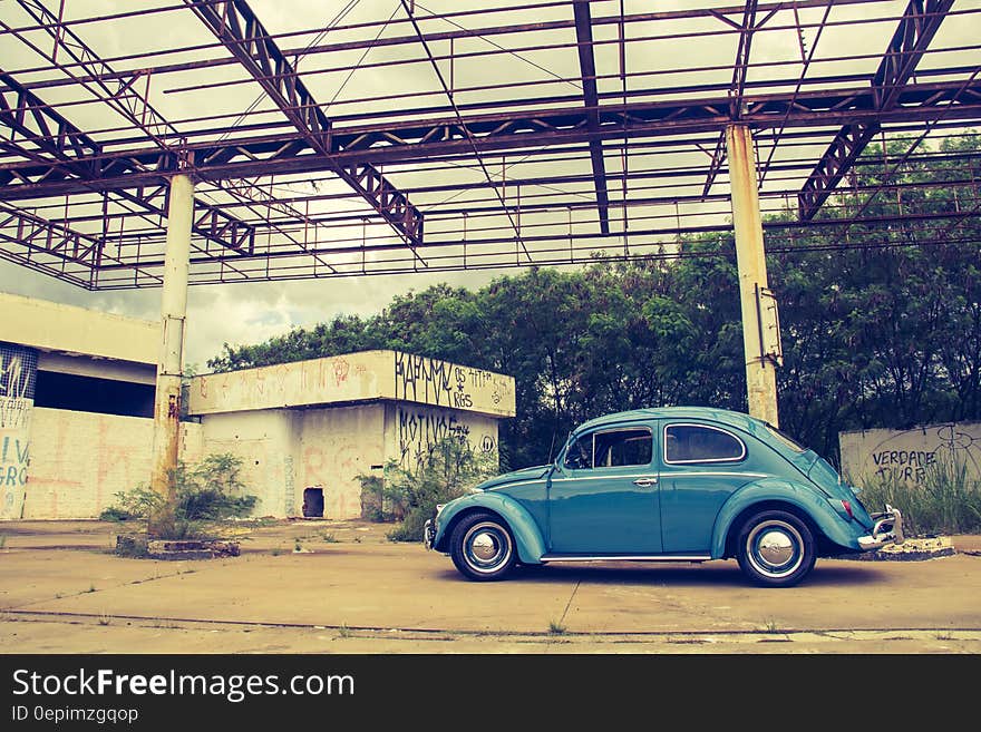 Blue Volkswagen Beetle in Front of Building