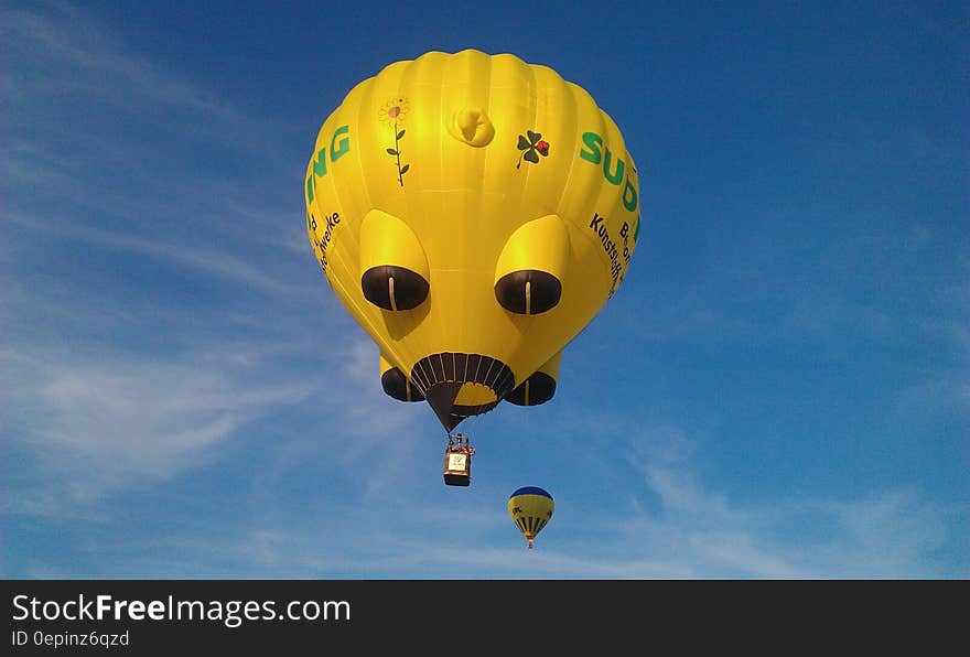 Yellow and Black Hot Air Balloons on Mid Air Under White Clouds Blue Sky during Daytime